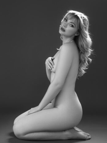 Kneeling fine art boudoir portrait photographed in timeless black and white