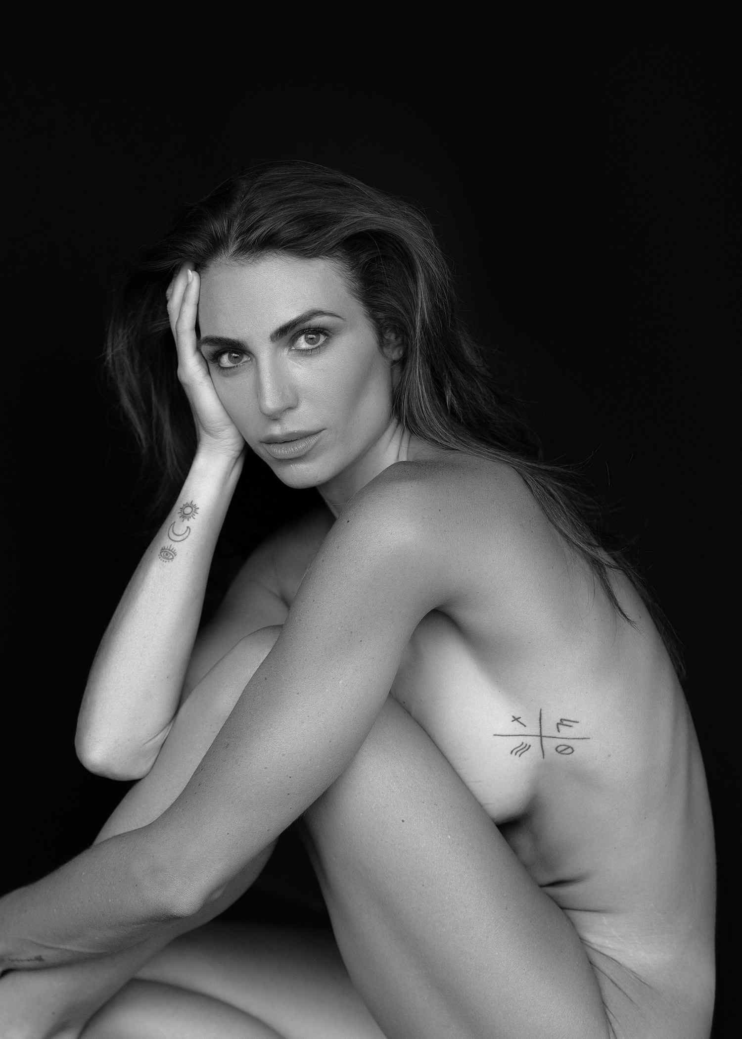 Close black and white intimate portrait with a soft gaze and gentle studio light